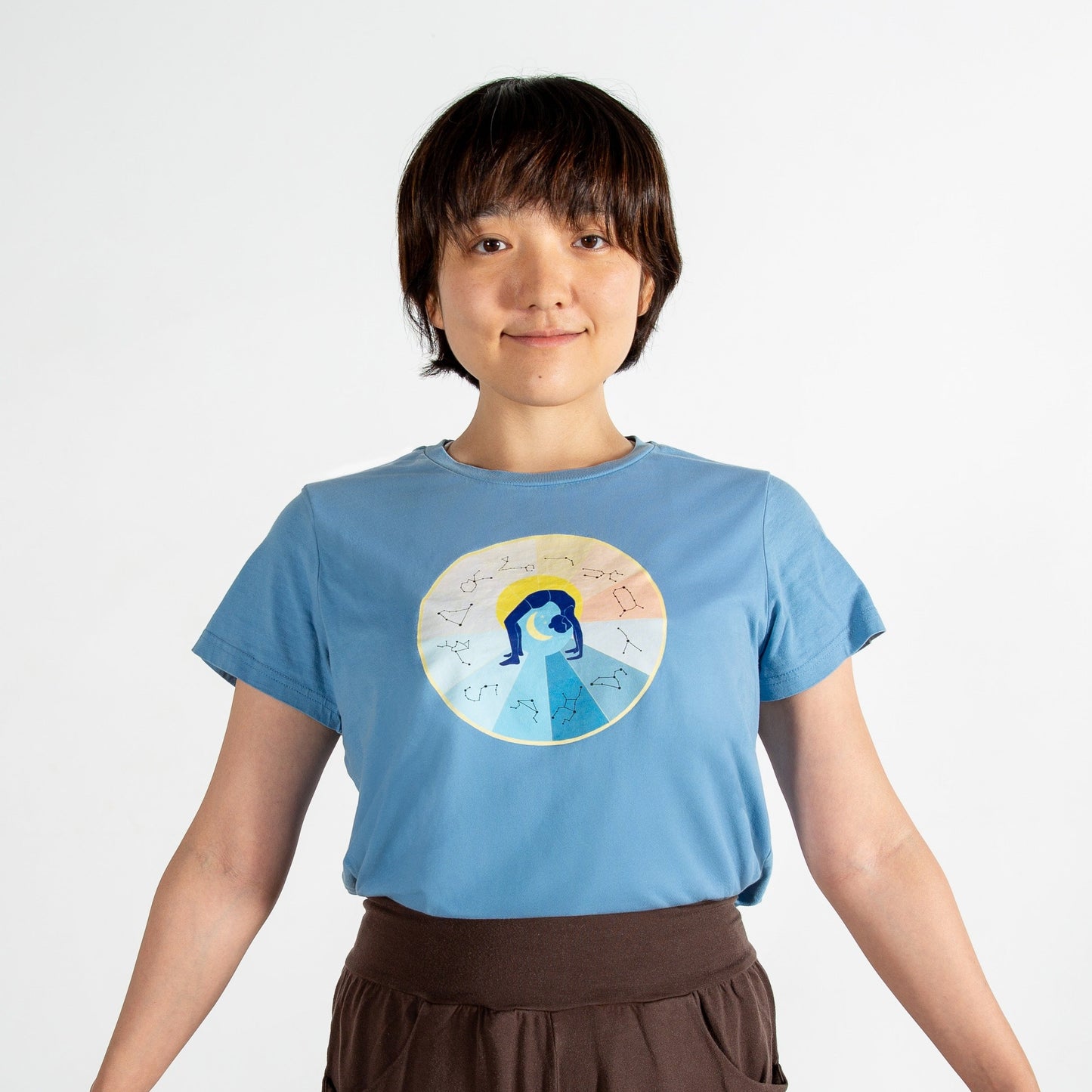 Person wearing a blue t-shirt with a graphic design on a plain background